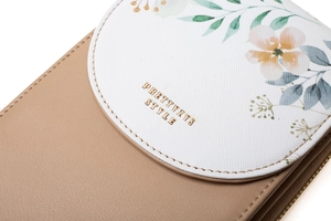 Close-up of leather floral flap and gold zipper on a touchscreen crossbody phone bag
