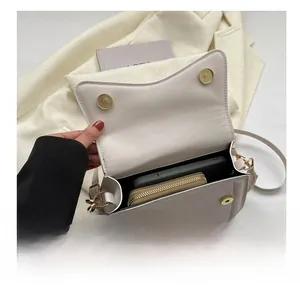 Interior capacity of the cream crossbody bag showing space for phone and wallet