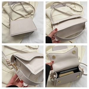 Detail view of cream crossbody bag featuring gold hardware and interior storage capacity