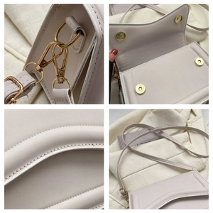 Close-up of minimalist beige crossbody bag showing gold metal hardware and fine stitching