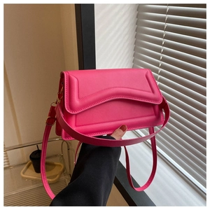 Detail of hot pink crossbody bag with 3D wave embossing and gold metal buckle