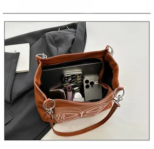 Top view of large capacity brown leather tote showing space for laptop and phone
