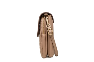Detail view of the triple compartment structure and gold zippers on the quilted crossbody bag