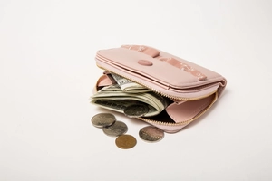 Close-up of pink leather wallet showing zipper, flower print and coin storage