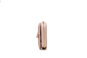 Detailed side view of a light pink zip-around wallet with golden metal zipper