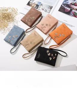 Detail of assorted matte PU leather wallets with floral embroidery and wrist straps