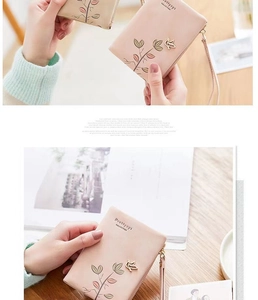 Detailed view of pink faux leather wallet with floral embroidery and bird ornament