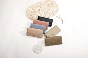 Flat lay of long flap wallets in six pastel colors with gold four-leaf clover hardware