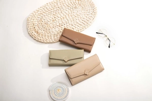 Detail of long tri-fold wallets with clover hardware buckle in multiple pastel colors