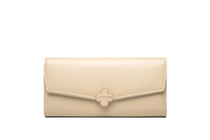 Close-up of beige leather wallet featuring a gold four-leaf clover metal buckle clasp