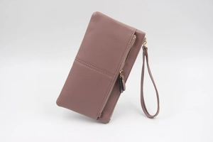 Détail de la texture en cuir PU rose et fermeture éclair dorée sur cette pochette tactile