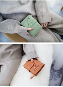 Close-up of matte leather wallets in green and caramel with zipper and buckle details
