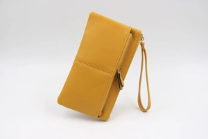 Détail de la texture cuir PU jaune grainé avec fermeture éclair dorée et dragonne amovible