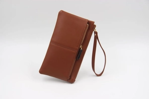Détail du portefeuille en similicuir marron avec zip doré et dragonne amovible pratique