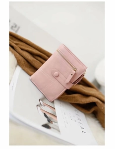 Detail of pink compact wallet with gold zipper and stylish white decorative stitching