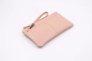 Détail de la pochette rose en similicuir avec trois fermetures éclair et texture grainée