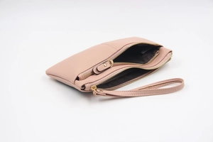 Détail de la pochette multifonction en similicuir rose avec double fermeture éclair et dragonne