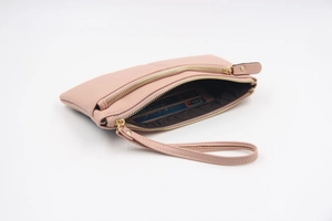 Détail d'une pochette rose en cuir PU avec double fermeture éclair et fentes pour cartes