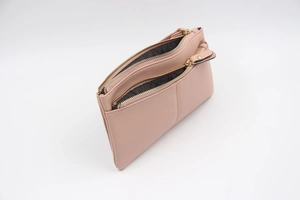 Détail d'une pochette en similicuir rose nude avec trois compartiments à zip doré