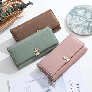 Three long women's wallets in brown and green with elegant floral gold metal clasps