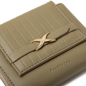 Close-up of olive green pebble leather wallet featuring vertical stitching and a gold X-metal accent