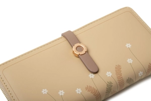 Close-up of floral buckle and daisy print on beige long PU leather wallet for women