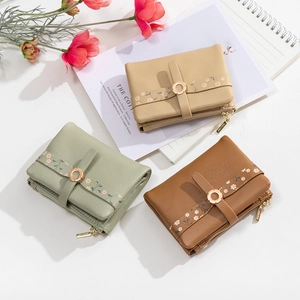 Short tri-fold women's wallets in beige and green with floral patterns and gold hardware