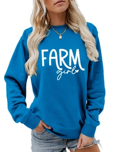 Close-up of white FARM girl art print on casual Klein blue long sleeve sweatshirt