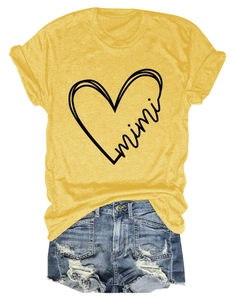 Detail of mimi heart print on ginger yellow t-shirt and distressed denim shorts