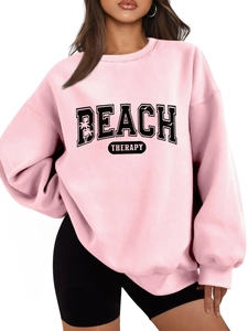 Detail of pink BEACH THERAPY oversized sweatshirt with black collegiate lettering