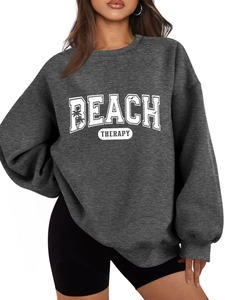 Detail of the white Beach Therapy lettering and palm tree design on a grey sweatshirt