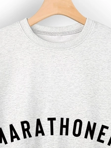 Close-up of heather grey crewneck sweatshirt with ribbed neck and Marathoner print