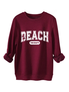 Close-up of BEACH THERAPY letter print and palm tree graphic on maroon sweatshirt