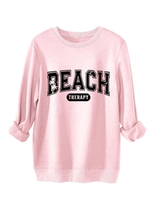 Close-up of the vintage BEACH THERAPY print on a pink crewneck cotton sweatshirt