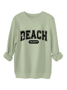 Close-up of the ribbed crewneck and Beach Therapy palm tree print on the sage green sweatshirt