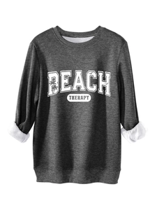 Detail of dark gray sweatshirt showing soft white fleece lining and BEACH THERAPY print
