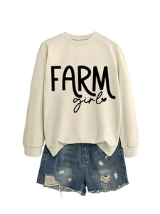 Flat lay of apricot sweatshirt with FARM girl lettering and ripped denim shorts