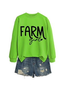 Detail of neon green Farm Girl sweatshirt paired with distressed denim shorts