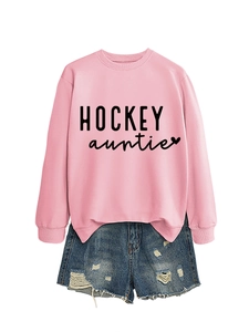 Détail du sweat rose clair avec texte Hockey Auntie et short en jean bleu déchiré