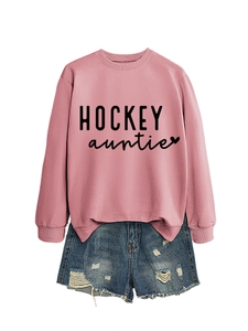 Sweat rose Hockey Auntie avec short en jean bleu délavé disposé à plat sur fond blanc