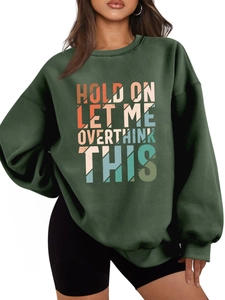 Detail of multi-colored lettering on oversized dark green thick cotton sweatshirt
