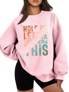 Detail of pink crewneck sweatshirt featuring retro artistic typography and drop shoulders