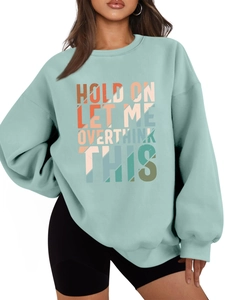 Detail of mint green sweatshirt with 'HOLD ON LET ME OVERTHINK THIS' graphic print