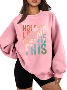 Detail of pink oversized sweatshirt featuring colorful retro slogan print on the chest