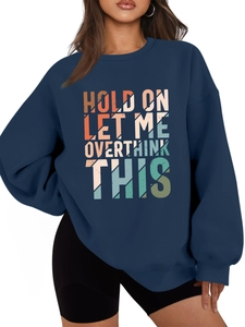 Detail of gradient slogan print on navy blue oversized sweatshirt with ribbed cuffs