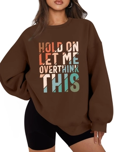 Detail of artistic lettering print on heavy dark brown oversized drop-shoulder sweatshirt