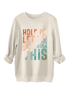 Close-up of vintage textured colorful slogan print on cream thick warm sweatshirt