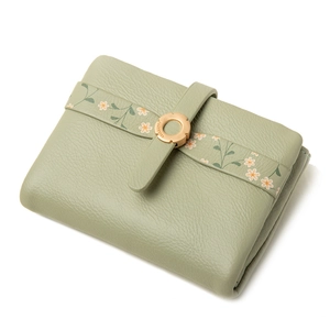 Detail of green PU leather wallet featuring floral strap and golden flower buckle