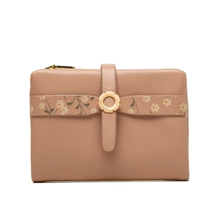 Detail of pink faux leather wallet featuring floral trim and engraved round metal clasp