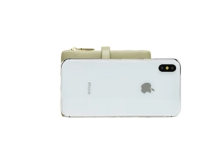Size comparison of light green leather wallet next to an iPhone on white background